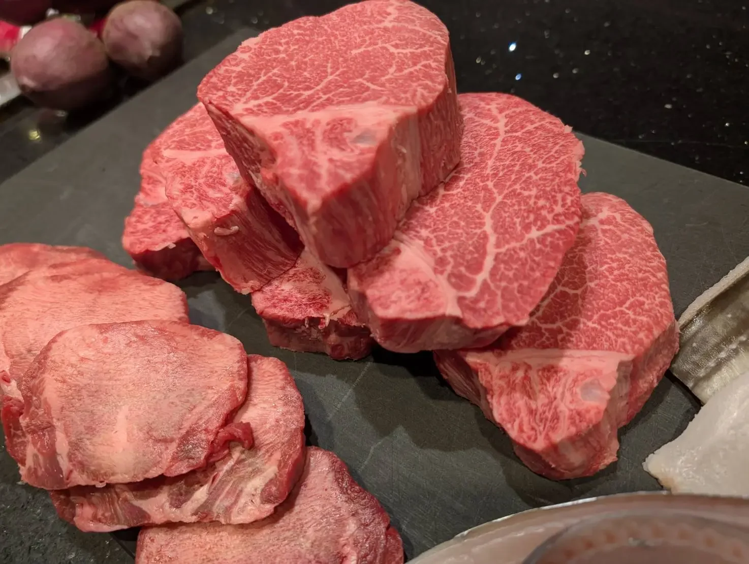 黒いまな板に並べた牛肉の切り身
